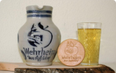 Ein Bembel (Gefäß für Apfelwein), ein Geripptes (Glas für Apfelwein) und ein Deckel mit Wehrheim Logo für das Glas.