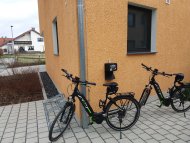 Zwei Fahrräder stehen an einer Hauswand.